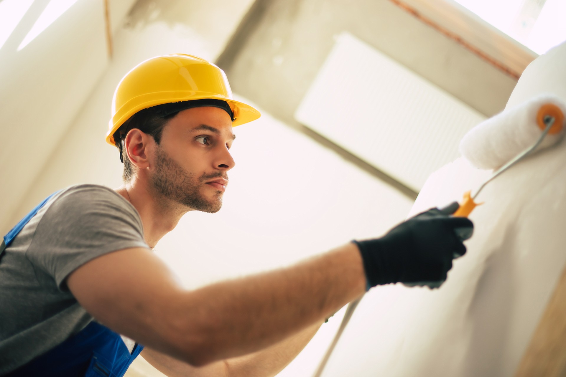 Young home repair male or worker busy with house renovation, holds building equipment, wears casual working clothes in the new build